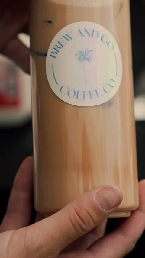 A sealed iced latte in a Brew and Go can, held up close